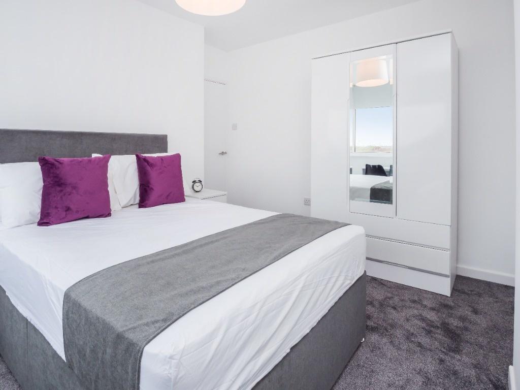 This stylish double bedroom features a comforta...