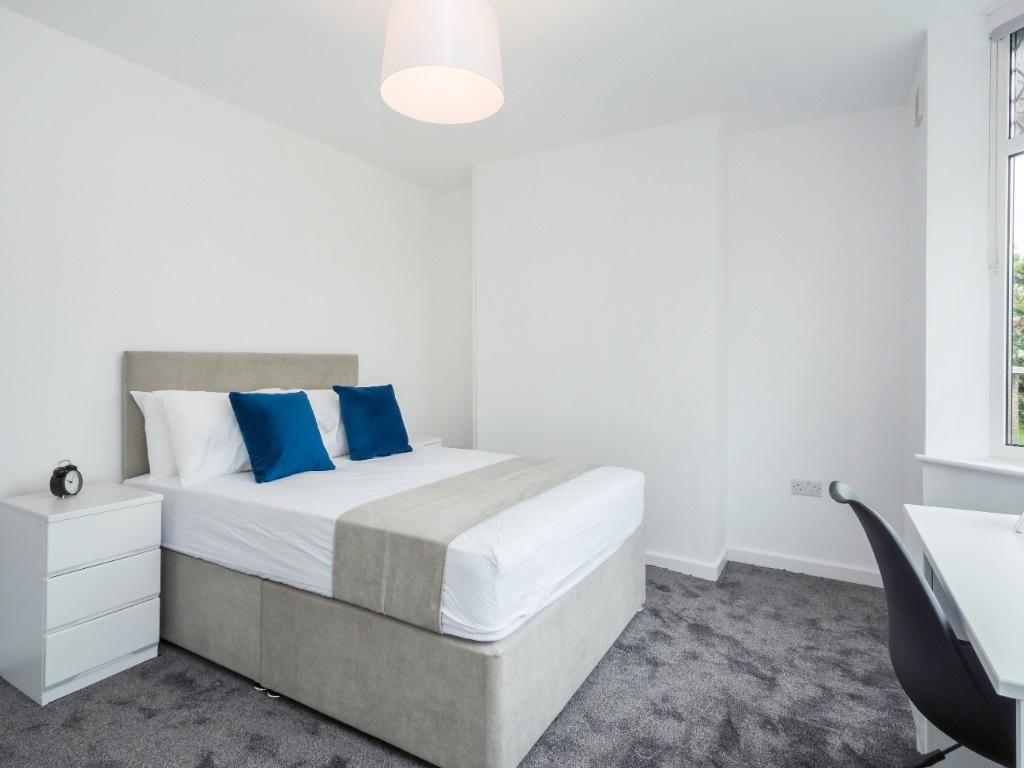 This cozy double bedroom features a comfortable...