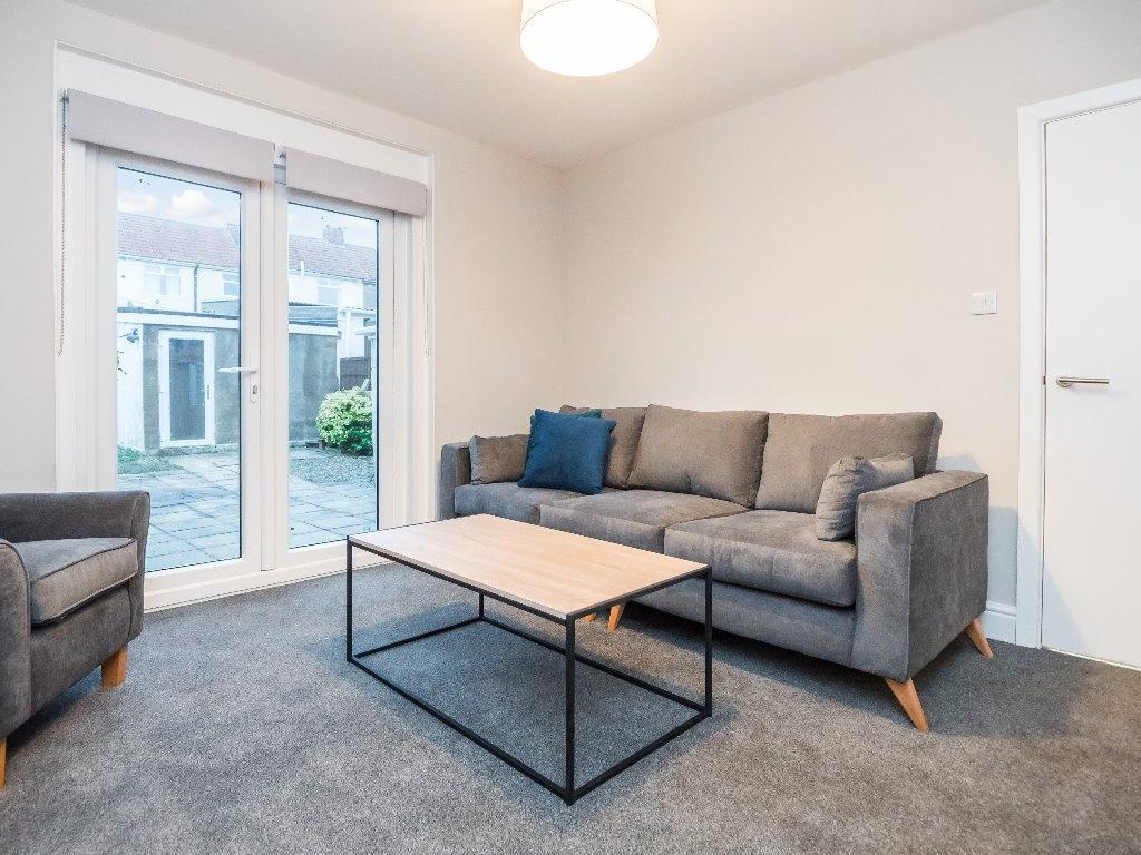 A modern living room with a comfortable grey so...