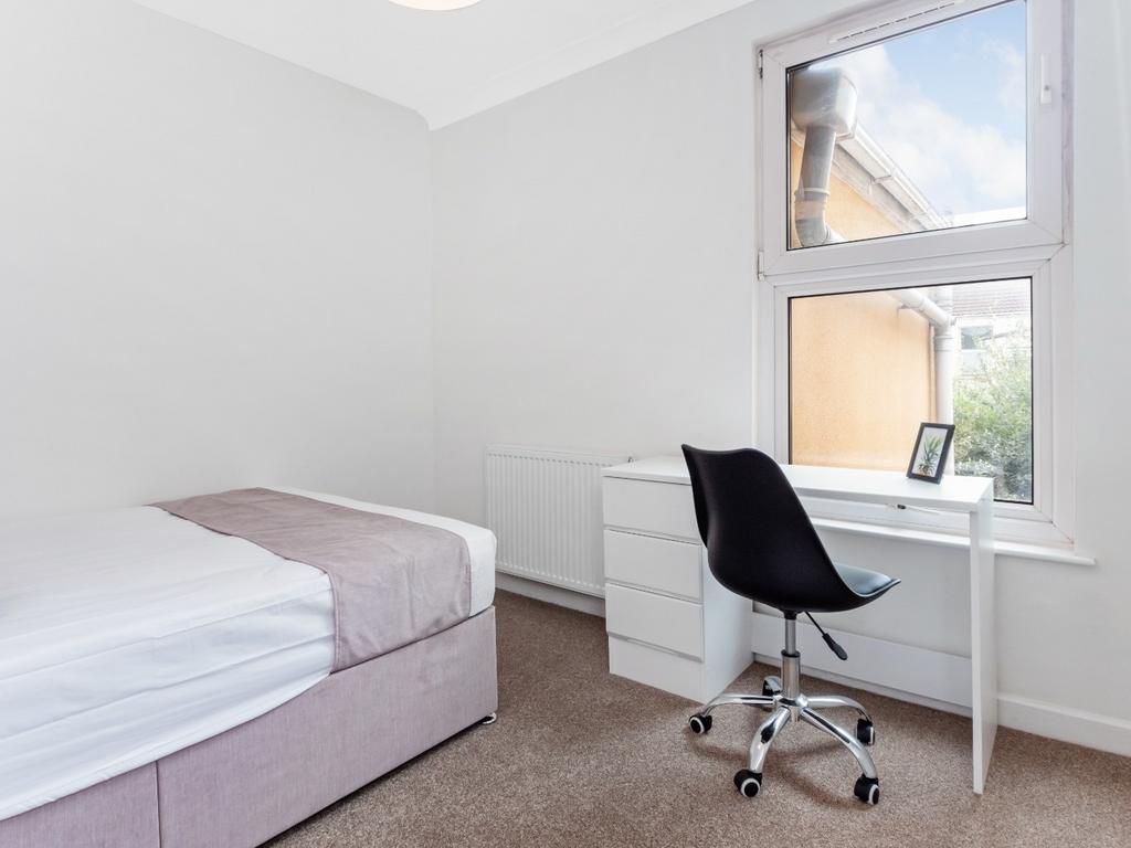 This cozy double bedroom features ample natural...