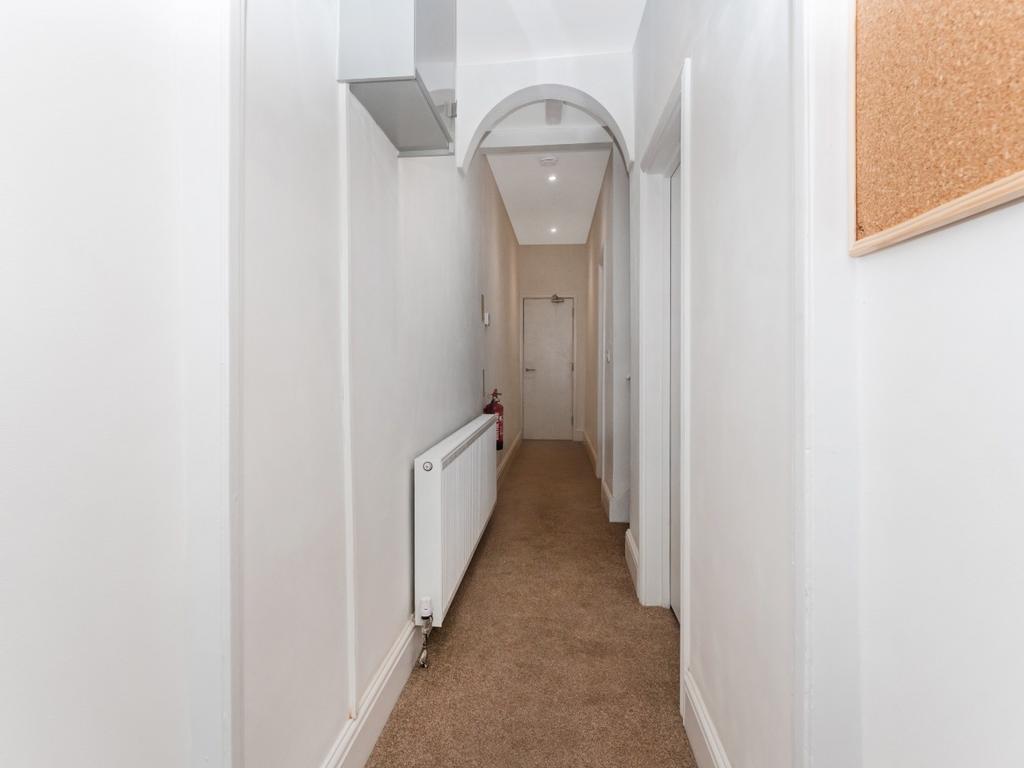 Bright and tidy hallway featuring warm carpetin...