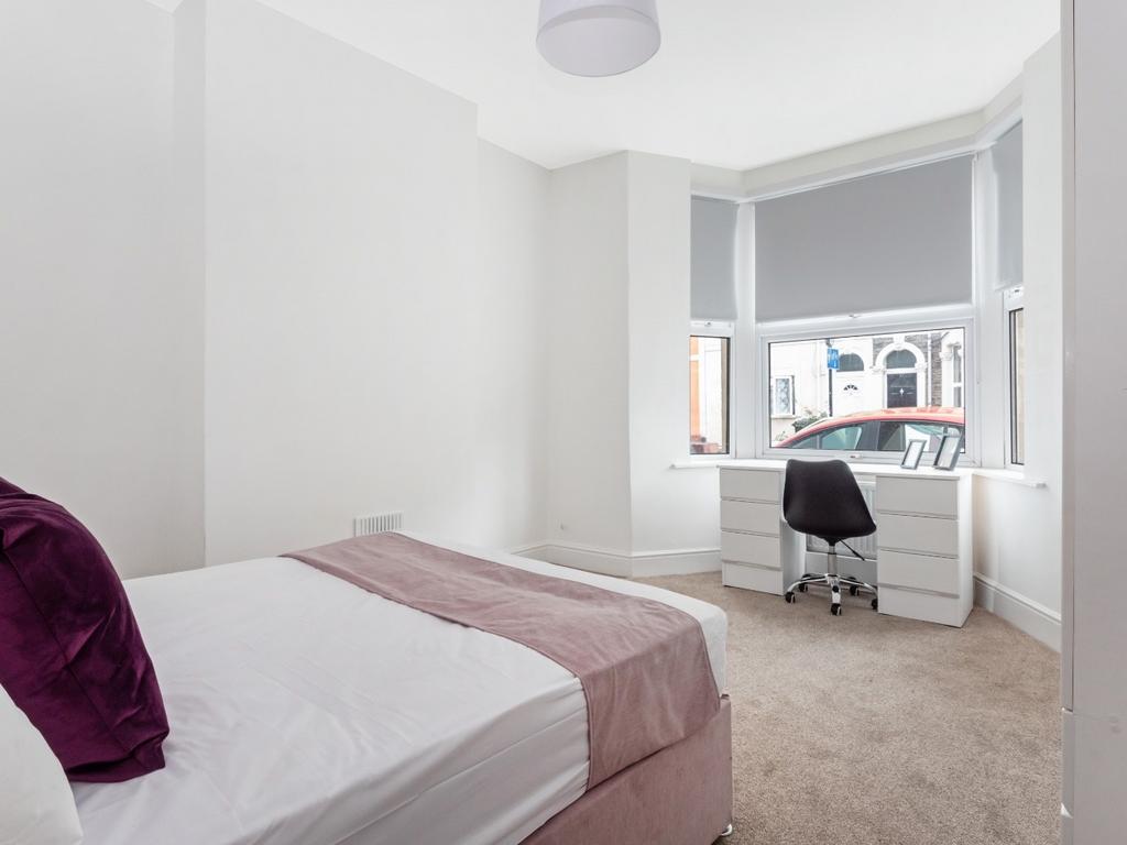 This inviting double bedroom features a cozy at...