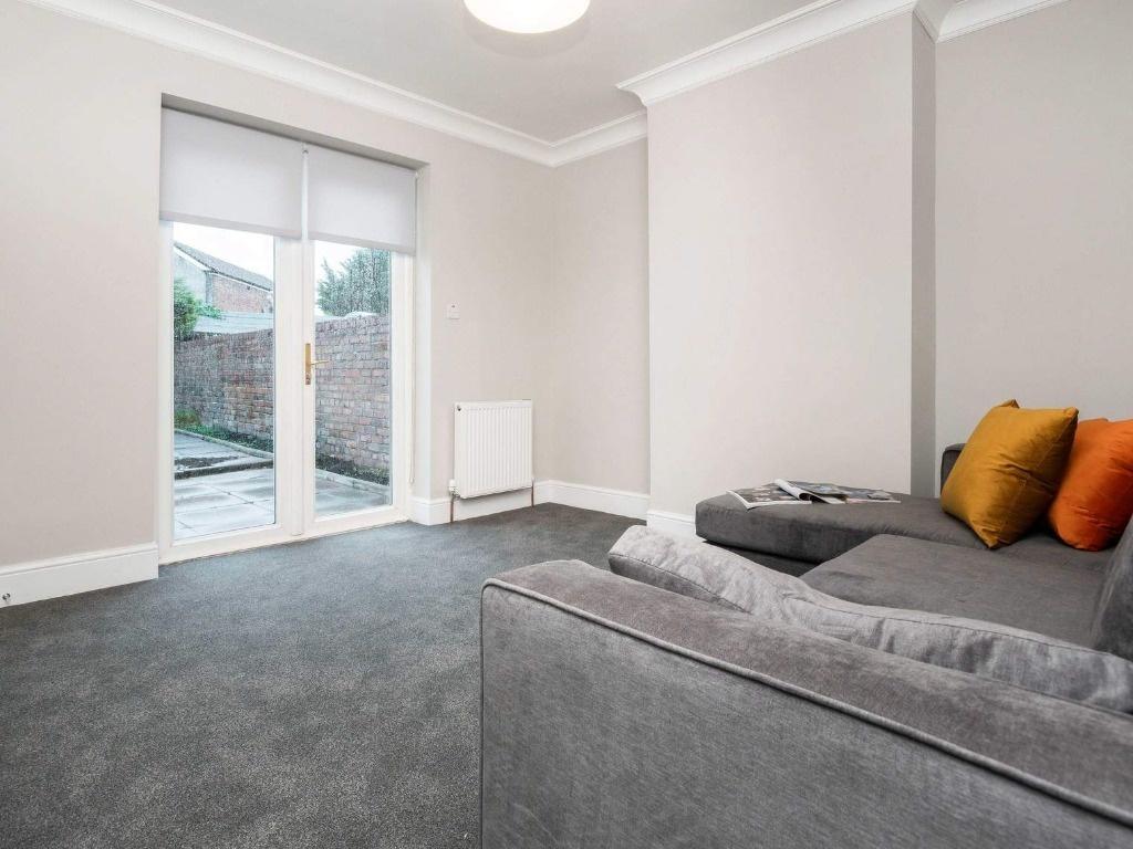 A bright and tidy living room featuring a comfo...