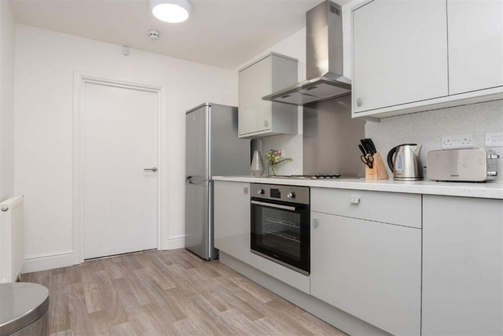 A modern and tidy kitchen featuring sleek grey ...