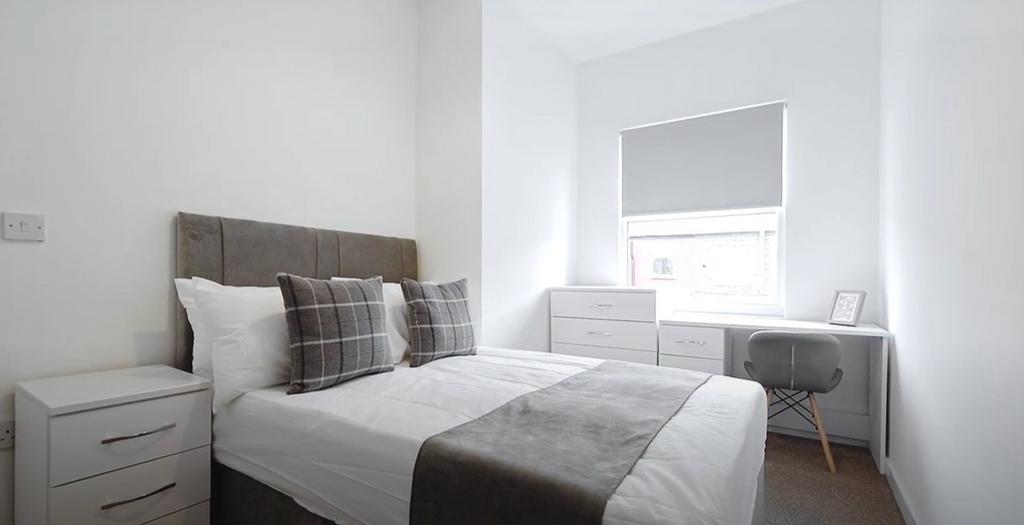 This inviting double bedroom features a cozy be...