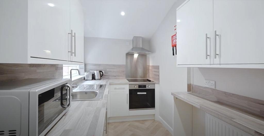 Modern kitchen featuring sleek white cabinetry ...