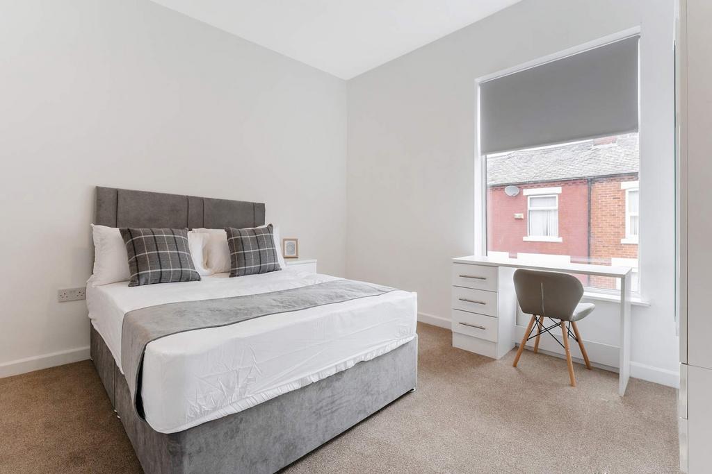 This stylish double bedroom features a comforta...