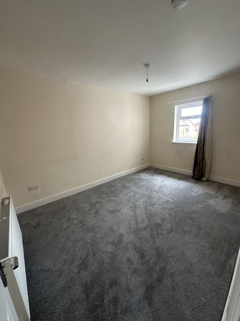 A spacious double bedroom featuring soft carpet...
