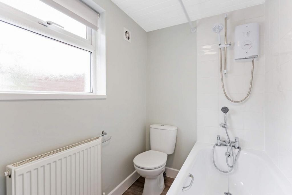 A bright and modern bathroom featuring a bath a...