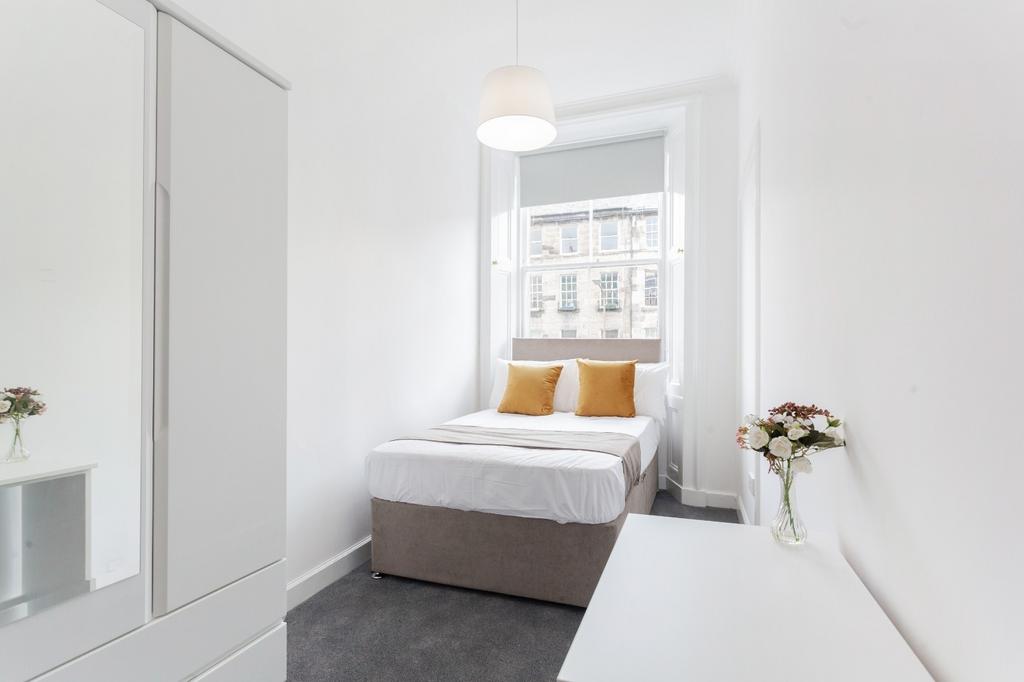 A bright and inviting double bedroom featuring ...