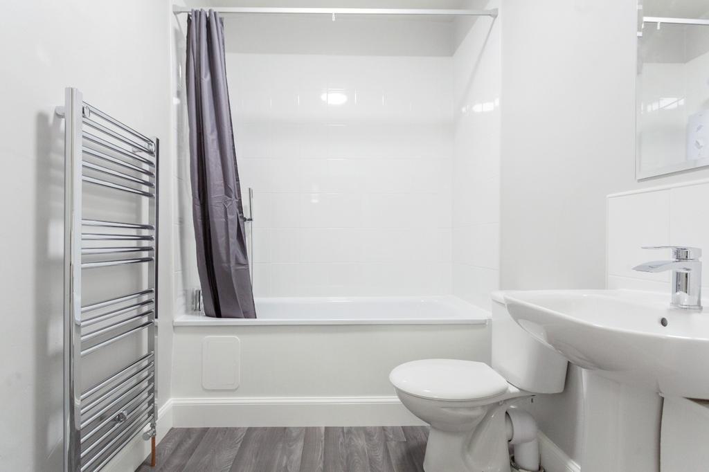 Bright and clean bathroom suite featuring a mod...