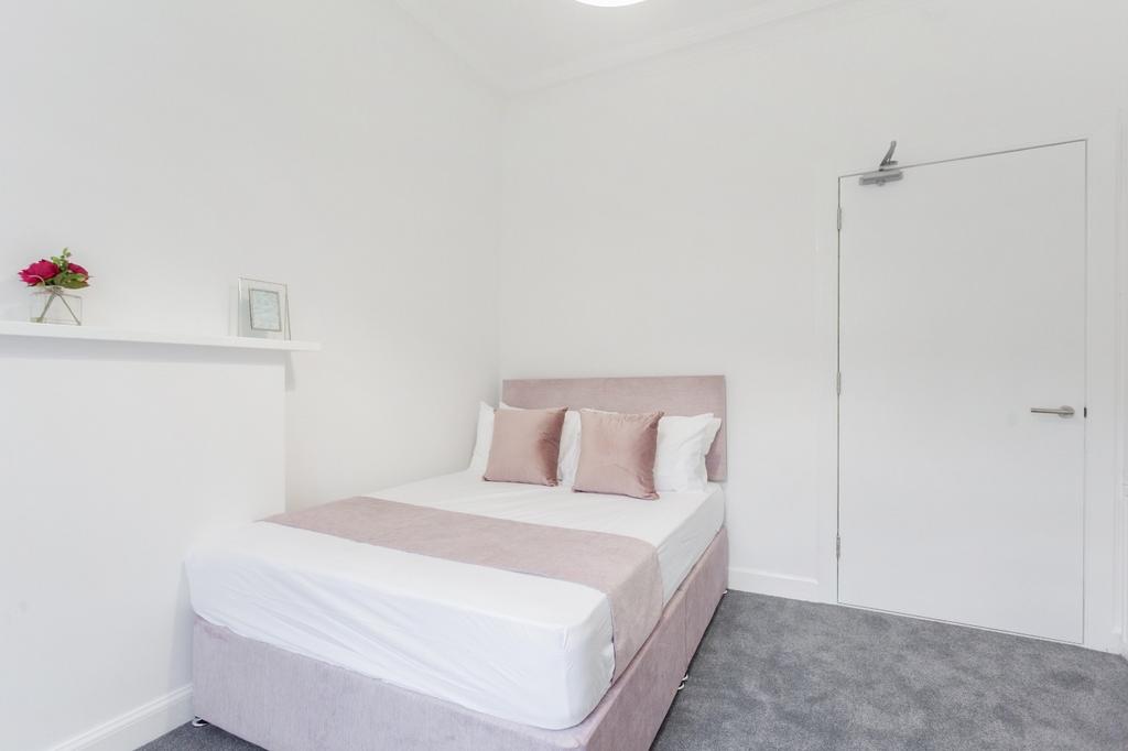 A bright and clean double bedroom featuring a c...