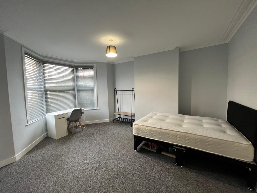 A spacious and bright double bedroom featuring ...