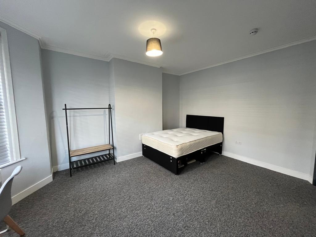A spacious and well-lit double bedroom, perfect...