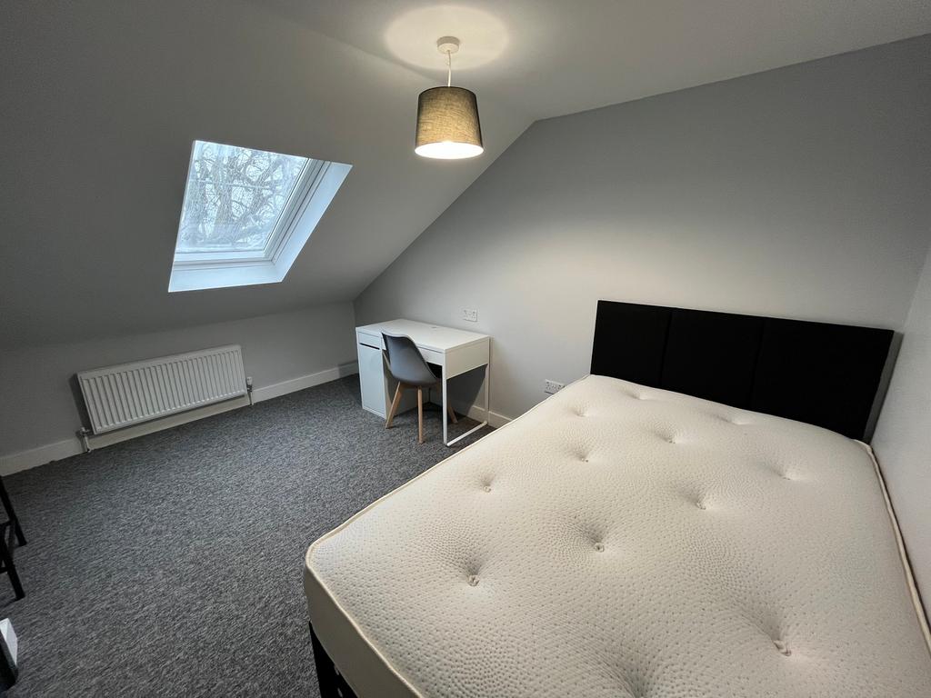 A spacious and inviting double bedroom with a m...