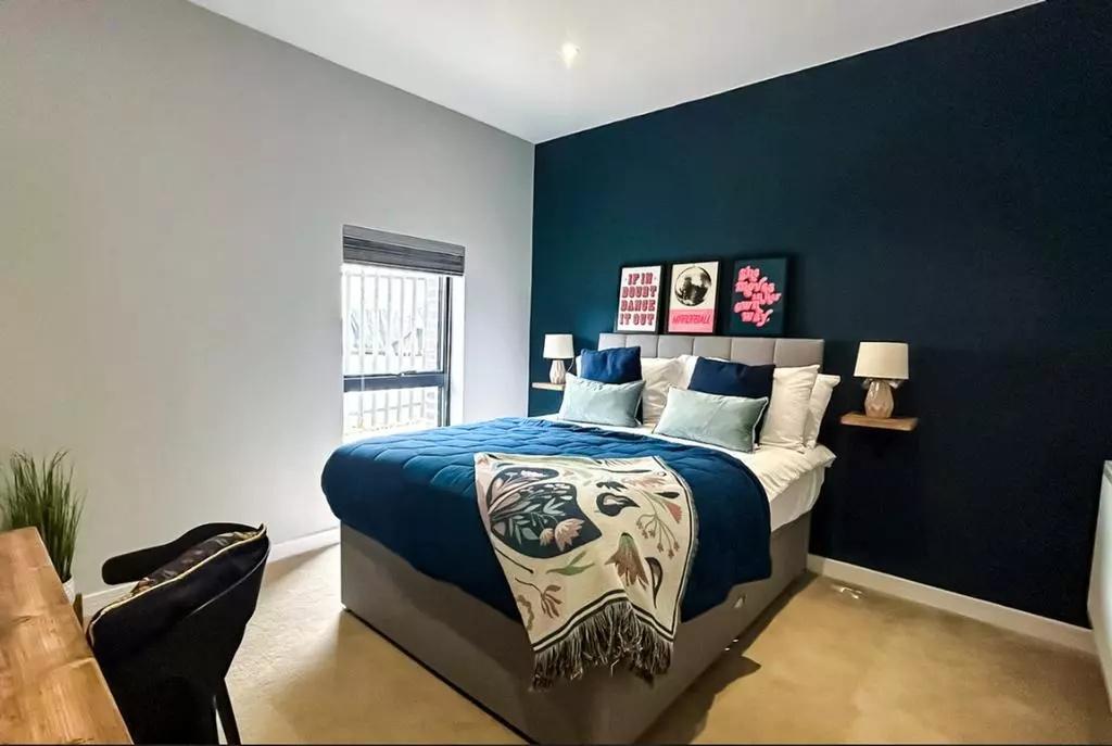 A stylish master bedroom featuring a comfortabl...