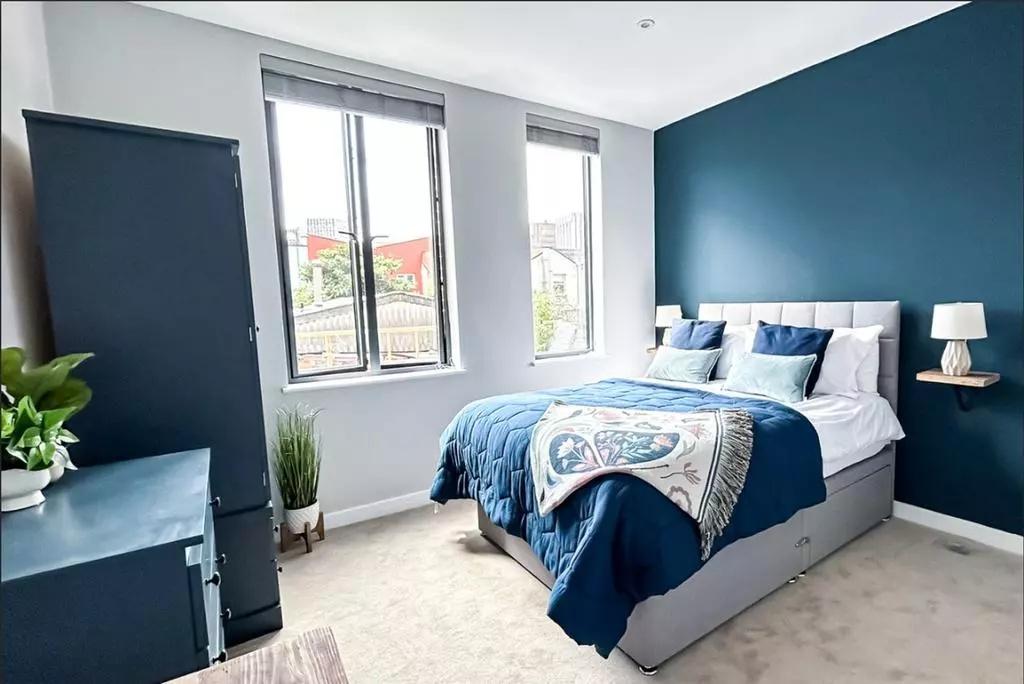 Bright and modern master bedroom featuring a co...