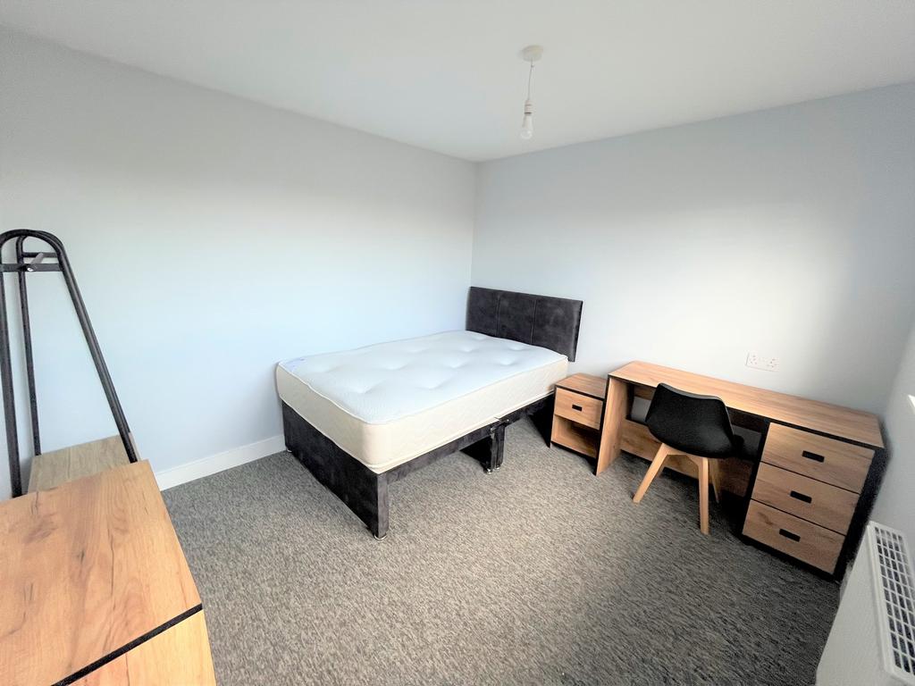 A spacious and tidy double bedroom featuring mo...