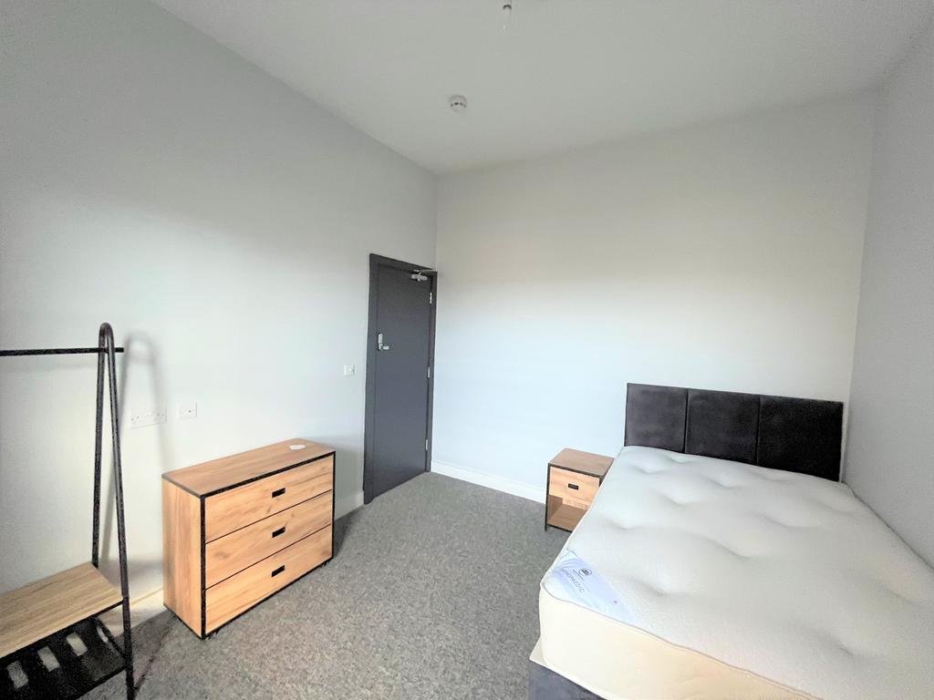 A bright and spacious double bedroom with moder...