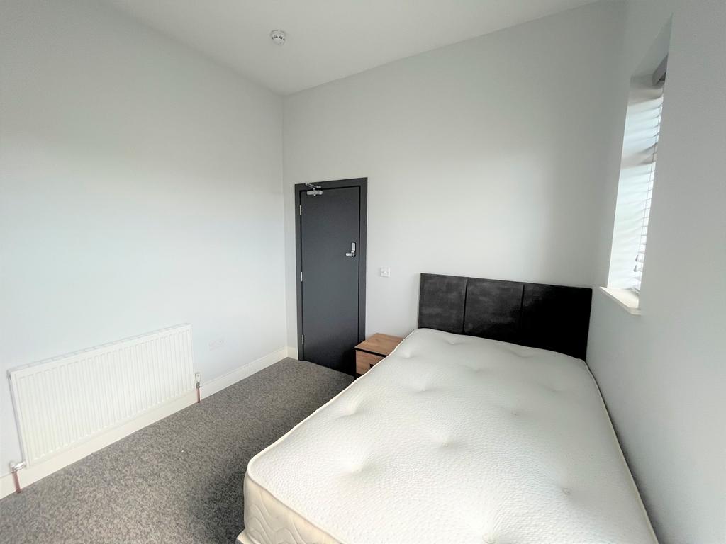 A spacious and bright double bedroom featuring ...