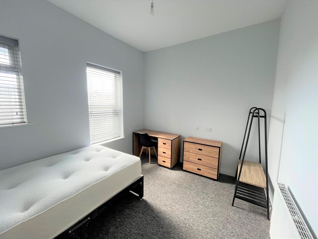 A spacious and bright double bedroom featuring ...