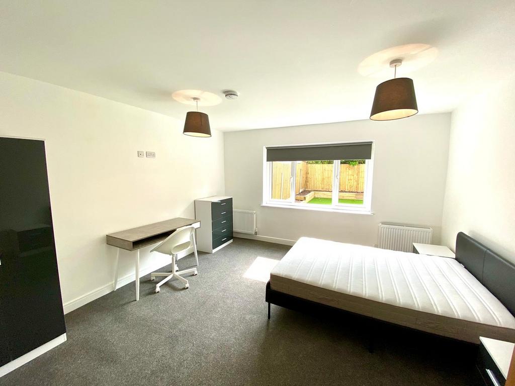 A spacious and well-lit double bedroom featurin...