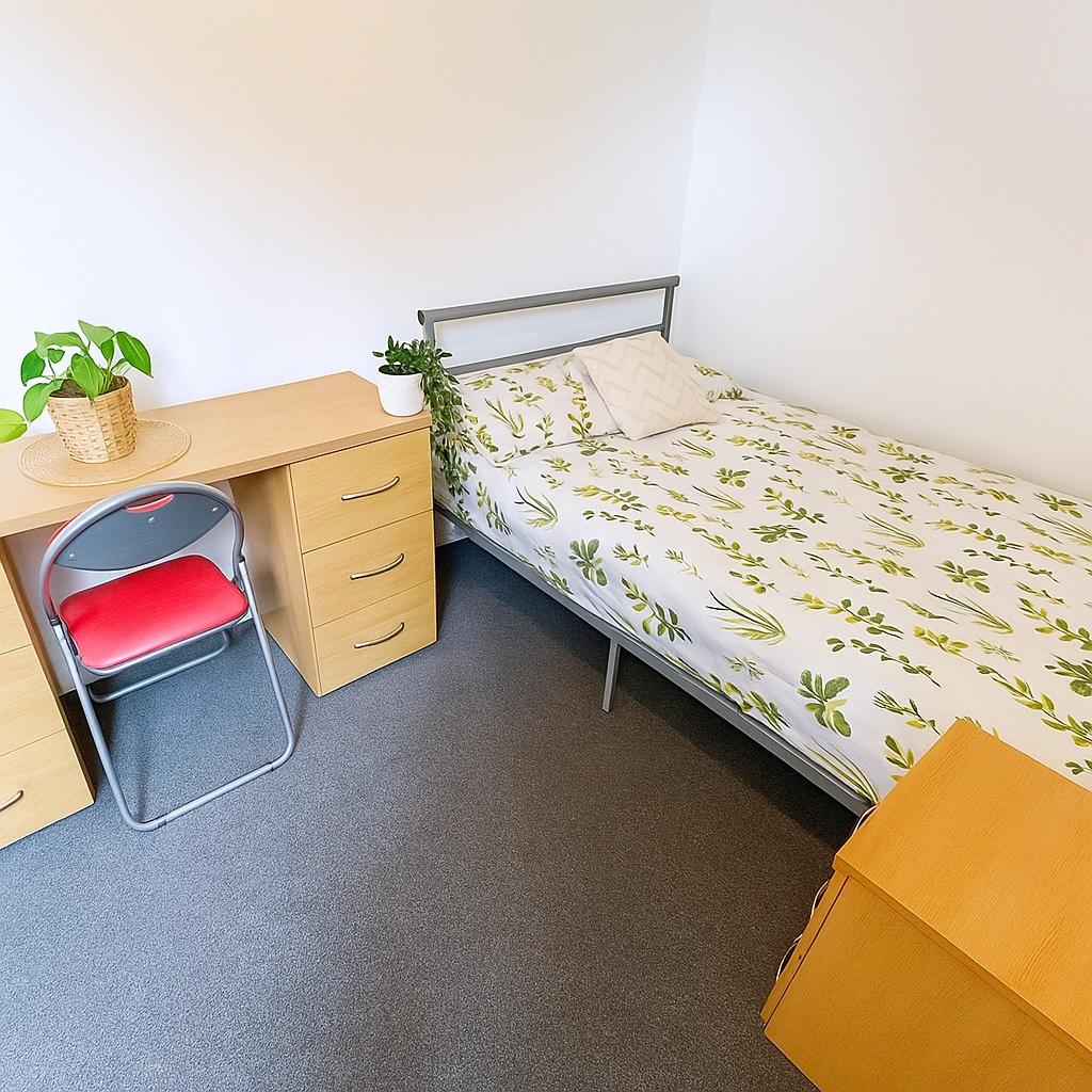 Neat single bedroom with a metal-framed bed dre...