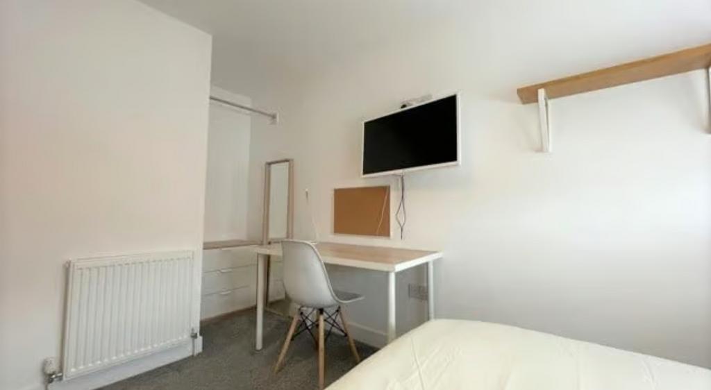 A neat and functional single bedroom featuring ...