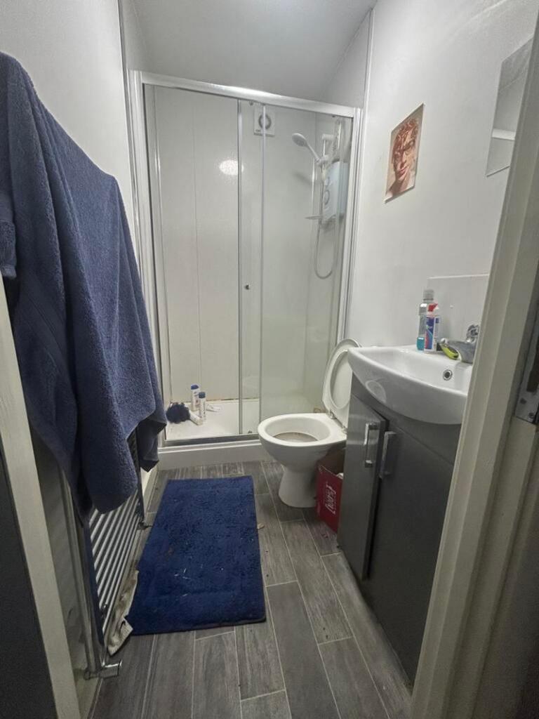 A modern bathroom featuring a spacious shower a...