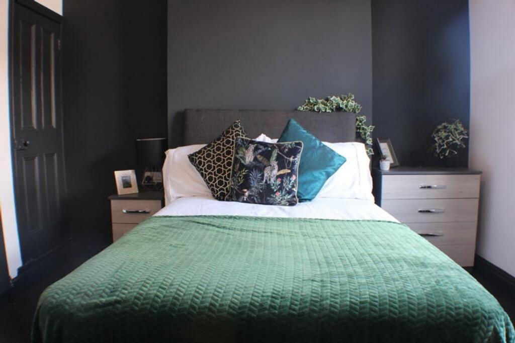 This inviting double bedroom features a cozy at...