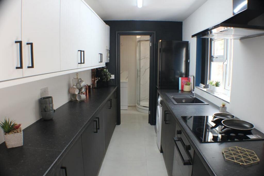 A modern kitchen featuring stylish black and wh...