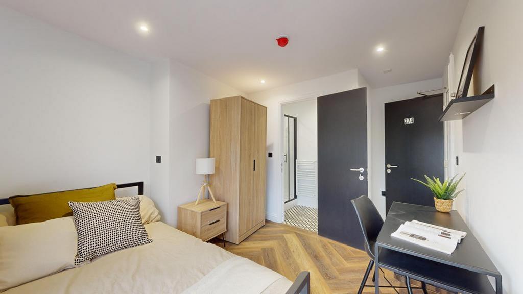 A bright and modern double bedroom featuring st...
