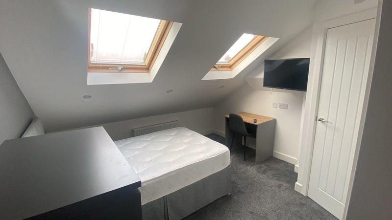 A clean and modern single bedroom featuring two...