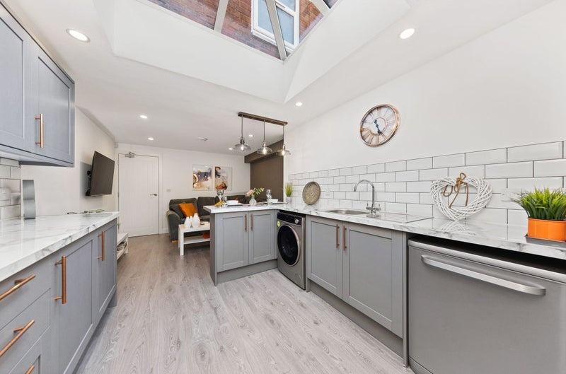 Bright and modern kitchen featuring stylish gre...