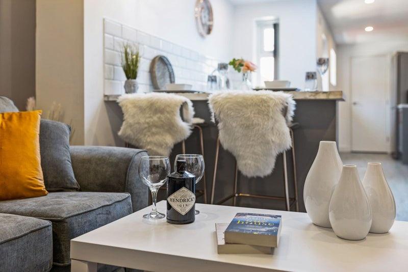 A contemporary living room featuring a cozy gre...