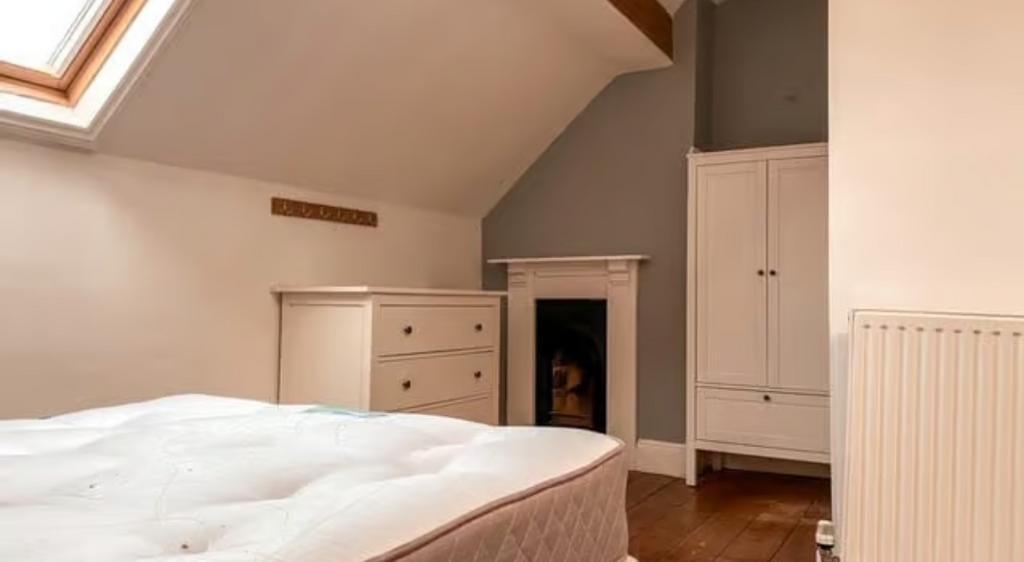 A cozy double bedroom featuring a bright skylig...