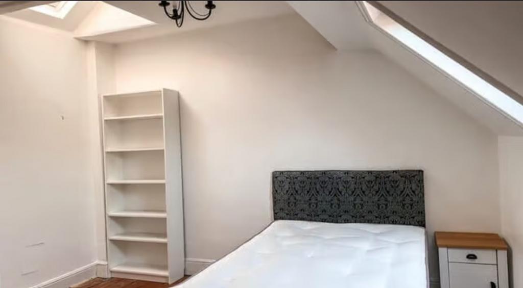 Bright attic double bedroom featuring a decorat...