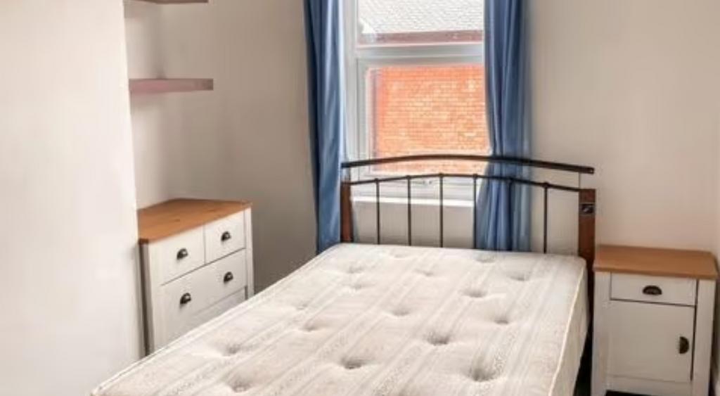 A bright double bedroom featuring a comfortable...