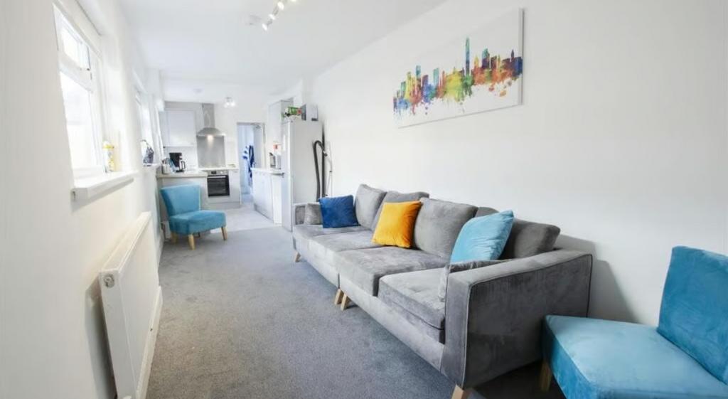 A bright and tidy living room featuring a comfo...