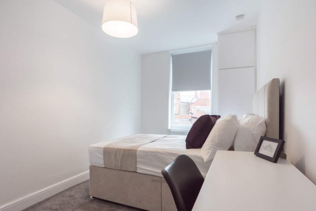 A modern and tidy double bedroom featuring a co...