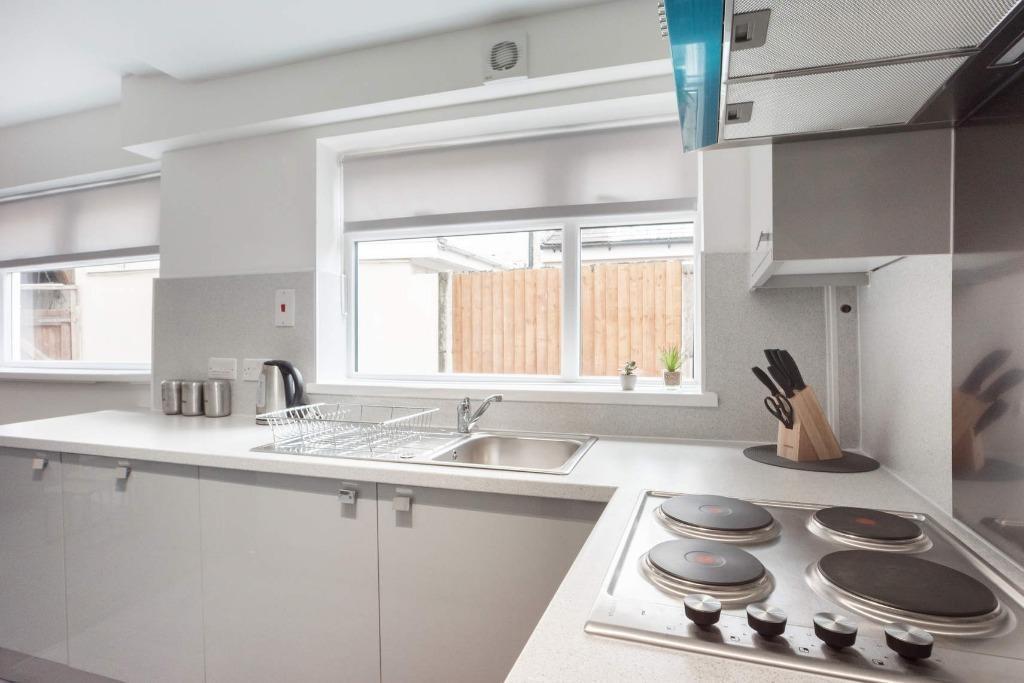 Bright and modern kitchen featuring sleek white...