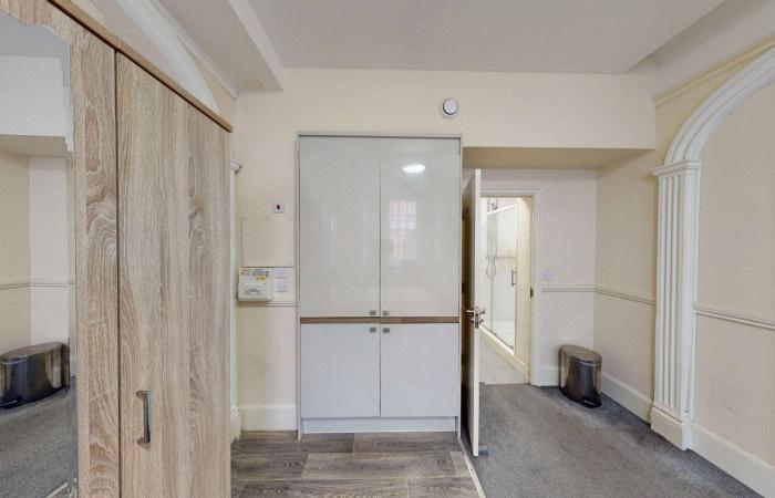 A tidy hallway featuring a modern white storage...