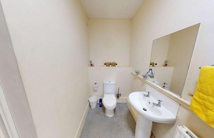A clean and simple single toilet room featuring...