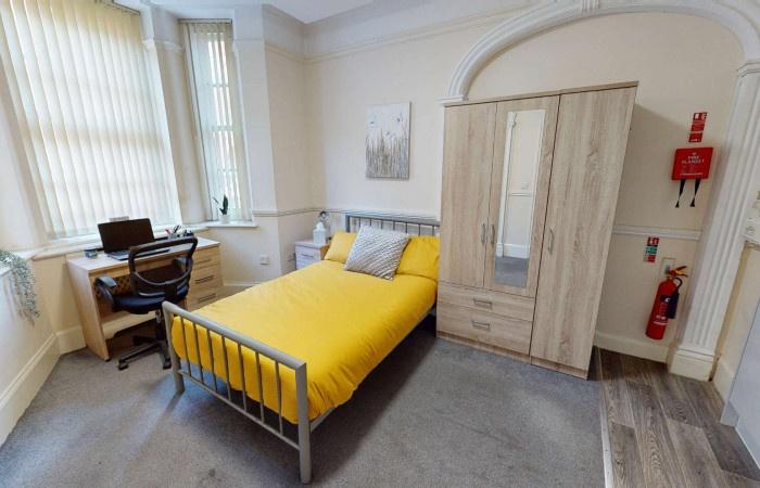 A bright and inviting single bedroom featuring ...