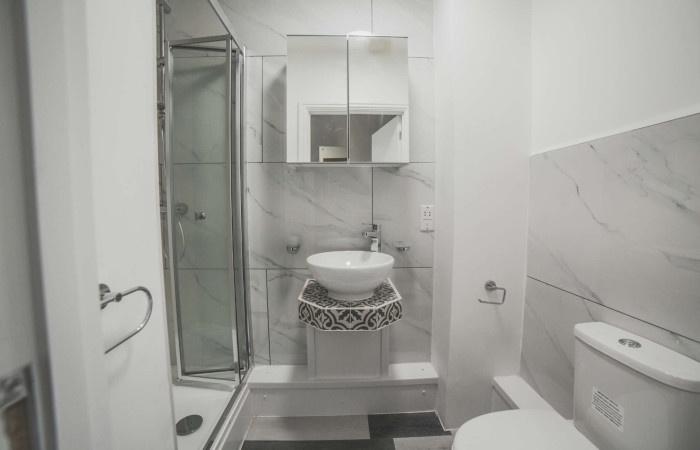 A modern and clean bathroom featuring a corner ...