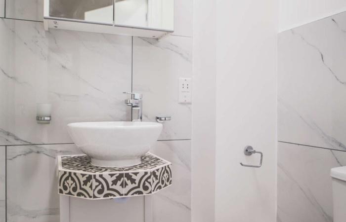 A modern bathroom featuring elegant marble-effe...