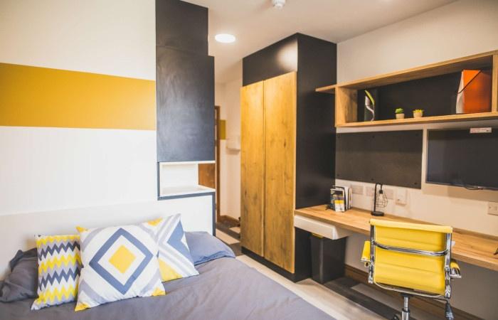 Bright and modern single bedroom featuring a co...