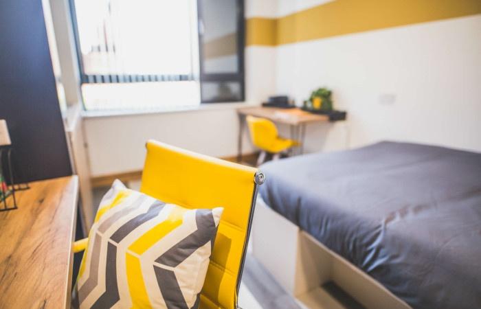 Bright and modern single bedroom featuring a co...