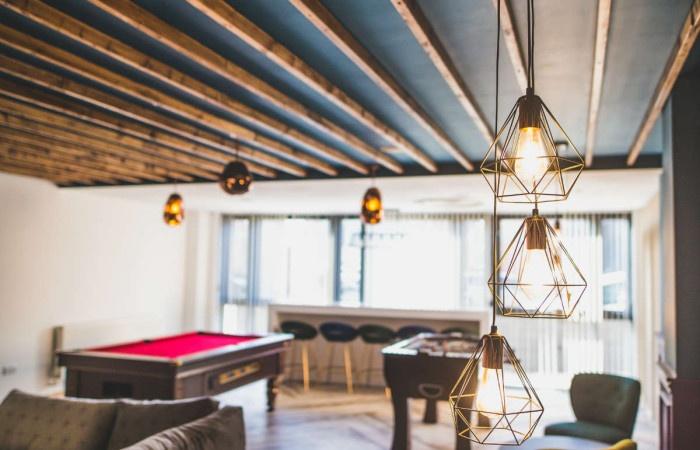 A stylish communal lounge featuring modern pend...