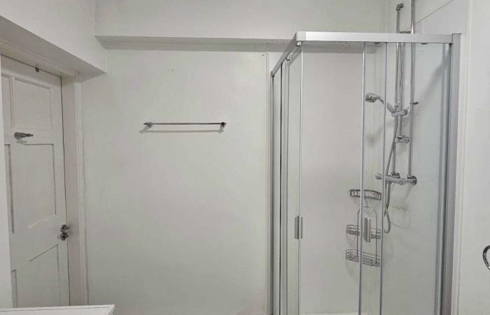 A clean and modern bathroom featuring a glass-e...